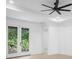 Bright bedroom with ceiling fan, light wood floors, and doors to the outdoor scenery at 2131 Brighton Ln, Orlando, FL 32817