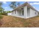 Rear of the home features a minimalist stucco exterior and a small patio with a ceiling fan at 2131 Brighton Ln, Orlando, FL 32817
