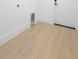Clean laundry room with hardwood style floor and a white door at 2131 Brighton Ln, Orlando, FL 32817