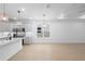 Open-concept living room with light wood floors, large window, and views into modern kitchen at 2131 Brighton Ln, Orlando, FL 32817