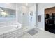 Bright bathroom featuring a glass enclosed shower, soaking tub, and walk-in closet at 2312 Panoramic Cir, Apopka, FL 32703