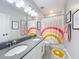 Bright bathroom featuring double vanity, and a playful rainbow-themed shower curtain at 2312 Panoramic Cir, Apopka, FL 32703