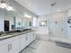 Contemporary bathroom with a double vanity, large mirror, and glass-enclosed shower at 2312 Panoramic Cir, Apopka, FL 32703