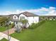Exterior aerial view of a home with a well-manicured lawn, brick driveway, and tropical landscaping at 2312 Panoramic Cir, Apopka, FL 32703