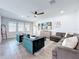 Living room featuring wood-look tile flooring, a ceiling fan, and a comfortable sectional sofa at 2312 Panoramic Cir, Apopka, FL 32703