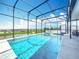 Stunning screened-in pool area with lights, spa and view of the green lawns and neighborhood beyond at 2312 Panoramic Cir, Apopka, FL 32703