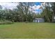 Spacious backyard featuring a storage shed with mature shade trees at 237 Church St, Lake Helen, FL 32744