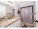Updated bathroom boasts granite vanity, shower with decorative curtain, and neutral color scheme at 237 Church St, Lake Helen, FL 32744