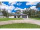 Lovely single-story home with a well-manicured lawn, gray roof, a paved driveway, and a two-car garage at 237 Church St, Lake Helen, FL 32744