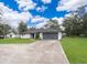 Beautiful single-story home with a well-manicured lawn, gray roof, a paved driveway, and a two-car garage at 237 Church St, Lake Helen, FL 32744