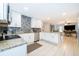 Well-lit kitchen boasts modern appliances, granite countertops, sleek white cabinetry, and an elegant tile backsplash at 237 Church St, Lake Helen, FL 32744
