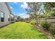 The backyard features a wooden fence, an arbor and a spacious grass area for outdoor activities and enjoyment at 249 Mill Slough Rd, Oviedo, FL 32766