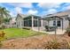 A view of the backyard, showing a patio, an enclosed lanai and lush green grass, offering an outdoor retreat at 249 Mill Slough Rd, Oviedo, FL 32766
