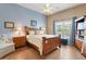 Comfortable bedroom with a wooden bed frame, side tables, lamps, light blue walls, and a window at 249 Mill Slough Rd, Oviedo, FL 32766