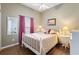 Cozy bedroom featuring a white bed frame, wood-look flooring, and pink curtains at 249 Mill Slough Rd, Oviedo, FL 32766