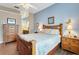 Bedroom showcasing a wooden bed, blue walls, and view to the ensuite bathroom with granite countertops at 249 Mill Slough Rd, Oviedo, FL 32766