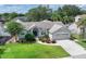 This is an exterior front view of a well-maintained home with mature landscaping, a lawn, and an attached garage at 249 Mill Slough Rd, Oviedo, FL 32766