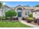 Attractive home entrance framed by landscaping featuring a curved walkway leading to an arched doorway at 249 Mill Slough Rd, Oviedo, FL 32766