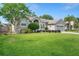 Charming exterior displaying a lush green lawn, mature trees, and a lovely walkway to the front door at 249 Mill Slough Rd, Oviedo, FL 32766