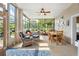 Bright sunroom featuring large windows, tile flooring, ceiling fan, and a casual seating and dining area at 249 Mill Slough Rd, Oviedo, FL 32766