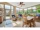 Light-filled sunroom with large windows, tile flooring, and comfortable seating area at 249 Mill Slough Rd, Oviedo, FL 32766