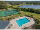 Aerial showcasing the community's pool, lake and tennis courts surrounded by beautiful landscape at 2498 Saint Augustine Blvd, Haines City, FL 33844