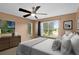 This bedroom has a ceiling fan, dresser, a large window with view, and decorative artwork at 2498 Saint Augustine Blvd, Haines City, FL 33844