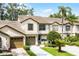 Inviting townhouse featuring a tile roof, two-car garage, and well-manicured landscaping at 2498 Saint Augustine Blvd, Haines City, FL 33844