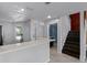 Modern kitchen with light countertops and stainless steel appliances, adjacent to dark-stained stairs at 2498 Saint Augustine Blvd, Haines City, FL 33844