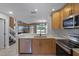 Modern kitchen with stainless steel appliances and quartz countertops overlooks the living area at 2498 Saint Augustine Blvd, Haines City, FL 33844