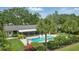 Backyard aerial view of the pool, spa, patio, lawn and landscaping, set within lush greenery at 2756 Summerfield Rd, Winter Park, FL 32792