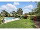 Backyard featuring a pool, jacuzzi, tropical plants, a manicured lawn, and golf course access at 2756 Summerfield Rd, Winter Park, FL 32792
