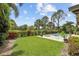 Expansive backyard featuring a pool, well-manicured lawn, tropical plants, and access to the golf course at 2756 Summerfield Rd, Winter Park, FL 32792