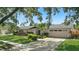 Inviting one-story home boasts lush landscaping, a brick facade, and a spacious driveway leading to a garage at 2756 Summerfield Rd, Winter Park, FL 32792
