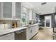 Contemporary kitchen featuring white cabinetry, granite countertops, stainless steel appliances, and hardwood floors at 2756 Summerfield Rd, Winter Park, FL 32792
