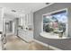 Bright open kitchen with white cabinets, modern appliances, a window with a view, and a stone countertop at 2756 Summerfield Rd, Winter Park, FL 32792