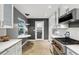 Bright kitchen featuring white cabinetry, stone countertops, and stainless steel appliances, complemented by a view from the window at 2756 Summerfield Rd, Winter Park, FL 32792