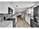 Updated kitchen featuring white cabinets, black appliances, tile backsplash and modern flooring at 2859 T C U Blvd, Orlando, FL 32817