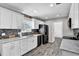 Well-lit kitchen with white cabinets, black appliances, tile backsplash and modern flooring at 2859 T C U Blvd, Orlando, FL 32817