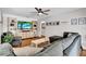 Comfortable living room features a cozy gray sectional sofa, entertainment center, and ceiling fan at 2859 T C U Blvd, Orlando, FL 32817