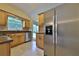 Bright kitchen with stainless steel appliances, wood cabinetry, and a window over the sink overlooking the yard at 309 Panama Cir, Winter Springs, FL 32708