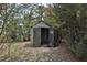 Outdoor shed surrounded by shrubbery with open doors reveals storage space at 309 Panama Cir, Winter Springs, FL 32708