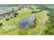 Aerial view of a picturesque golf course with lush green fairways and a serene pond at 3149 Songbird Cir, Harmony, FL 34773