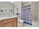 Well-lit bathroom with a vanity, framed mirror, shower with a striped curtain, and nautical-themed decor at 3149 Songbird Cir, Harmony, FL 34773