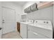 Bright laundry room with white washer, dryer, sink, and convenient storage shelves at 3149 Songbird Cir, Harmony, FL 34773