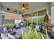 Comfortable covered patio with wicker furniture, decorative ceiling fan, and serene backyard view at 3149 Songbird Cir, Harmony, FL 34773