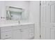 Bathroom vanity area featuring white cabinets, a large framed mirror, and a white sink at 315 Glenview Blvd # 3, Daytona Beach, FL 32118