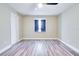 Bright bedroom with wood floors, a ceiling fan, and a large window with neutral-colored curtains at 315 Glenview Blvd # 3, Daytona Beach, FL 32118