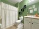 Bright green bathroom with shower, toilet, vanity, and decorative shelving at 318 Briarbrook Ln, Haines City, FL 33844