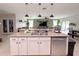 Open-concept kitchen island with a stainless steel dishwasher, sink, and granite countertops at 318 Briarbrook Ln, Haines City, FL 33844